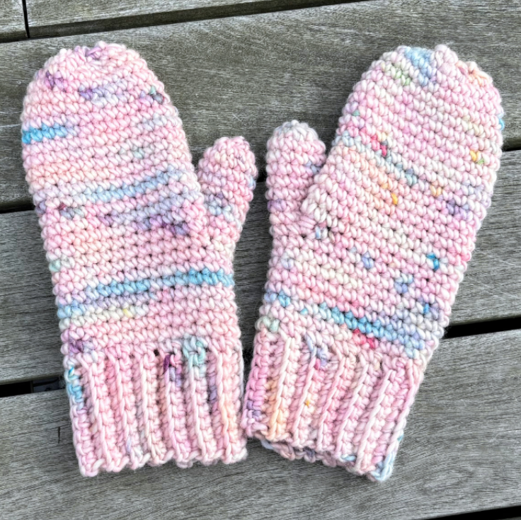 hæklede luffer i garn fra we are knitters. på et træbord